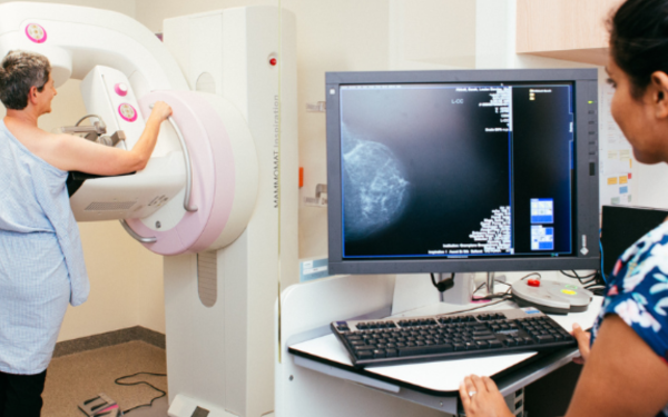 mammogram in progress with client radiographer and reading screen